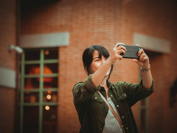 Asian woman using smartphone with happy mood in shopping mall - Φωτογραφία, εικόνα