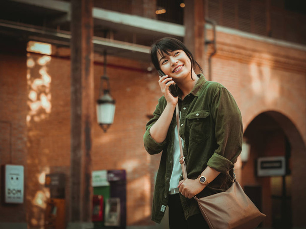 Asian woman using smartphone with happy mood in shopping mall - Fotoğraf, Görsel