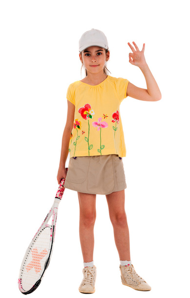 Маленькая девочка с теннисной ракеткой показывает хорошо на белом пляже
 - Фото, изображение