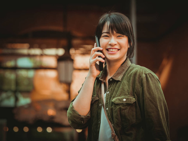 Asian woman using smartphone with happy mood in shopping mall - Foto, Imagen