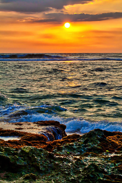 Una hermosa puesta de sol con colores cálidos y luminosos en oro, naranja, rojo, sobre el salvaje Océano Índico en Asia en la fascinante isla tropical Sri Lanka
 - Foto, imagen