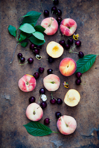 Fresh peaches and cherries on brown wooden background - Foto, imagen