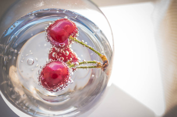 レモネードの夏の飲み物。ドリンク新鮮なフルーツ風味のグラス。ガラスで爽やかなドリンクを飲みながら夏の桜。コピー スペース - 写真・画像