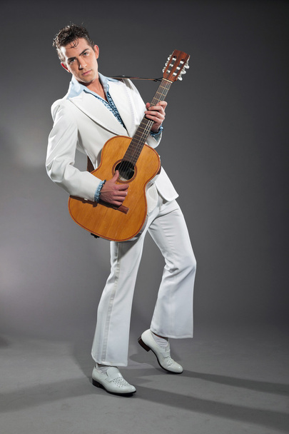 Retro rock and roll male guitar player wearing white suit. Studi - Foto, imagen