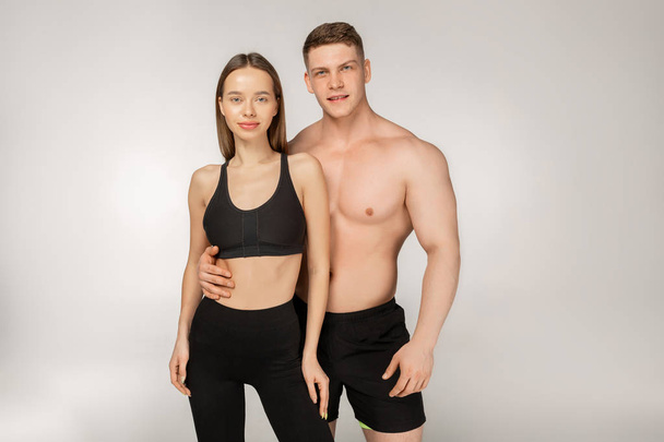 Young athletic shirtless man and beautiful woman in black sportswear - Foto, Imagem