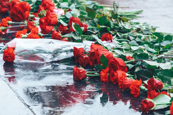 Red roses lie on the black granite - Photo, Image