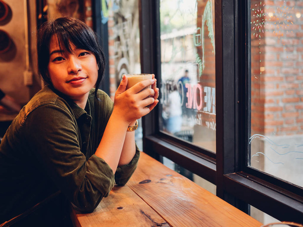 Mujer asiática bebiendo café en cafetería
   - Foto, imagen