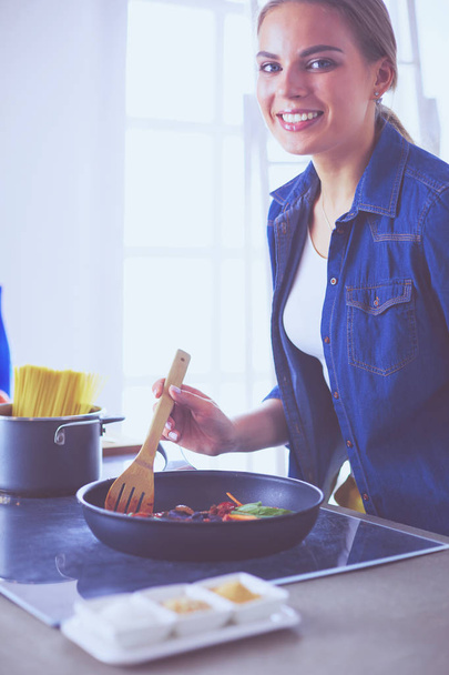 Young woman in the kitchen preparing a food - Fotoğraf, Görsel