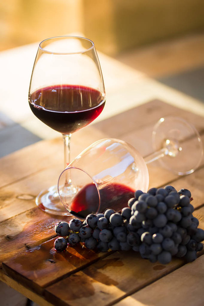 Kırmızı bir kadeh şarap devrik bardak şarap, şarap akan, sarhoşluk veya başarısız kavramı - Fotoğraf, Görsel