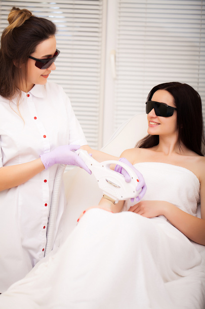 Hautpflege. Erwachsene Frau mit Laser-Haarentfernung in professionellem Schönheitssalon - Foto, Bild