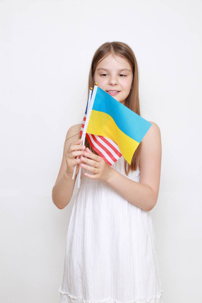 little girl holding Ukrainian and American flags - Foto, Imagen