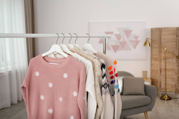 Wardrobe rack with stylish warm clothes indoors. Space for text - Φωτογραφία, εικόνα