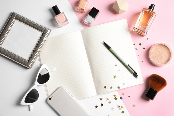 Flat lay composition with blank notebook, cosmetics and phone on color background, space for text. Blogger's workplace - Foto, afbeelding