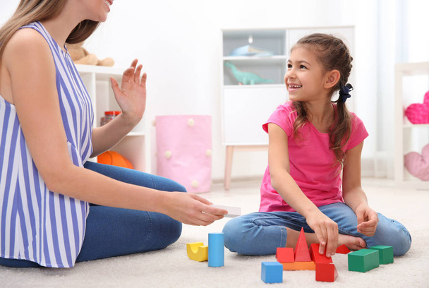 Woman and her child playing together with colorful blocks at home - Fotoğraf, Görsel