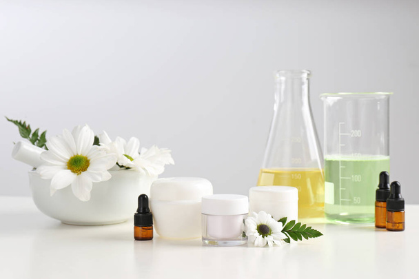Skin care products, ingredients and laboratory glassware on table. Dermatology research - Fotó, kép