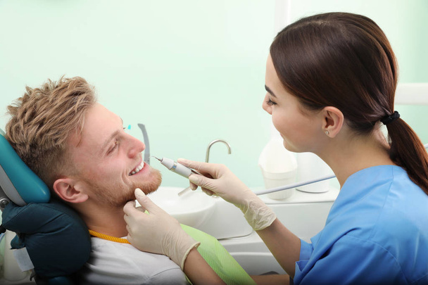 Professional dentist working with patient in modern clinic. Teeth whitening - Fotoğraf, Görsel