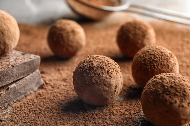 Sweet raw chocolate truffles powdered with cocoa on table - Foto, afbeelding