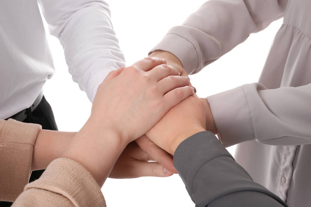 Група людей тримає руки разом на білому тлі, крупним планом
 - Фото, зображення