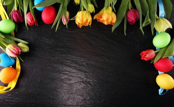 Colorful Easter eggs and tulips on rustic table - Fotoğraf, Görsel