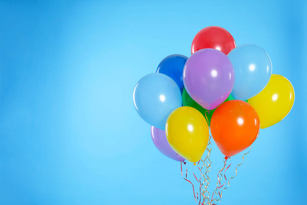 Bunch of bright balloons on color background. Space for text - Foto, Imagen