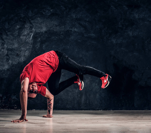 Μοντέρνο τύπος εκτελεί ακροβατικά στοιχεία breakdance. - Φωτογραφία, εικόνα