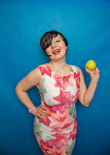 mollige plus size Frau mit grünem Apfel auf solidem Hintergrund - Foto, Bild
