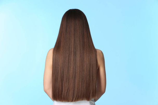 Woman with long brown hair on color background - Photo, Image