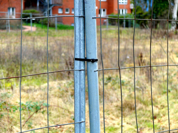 Portes dans la clôture métallique fermée par la bande en plastique
. - Photo, image