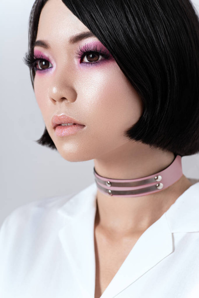 portrait of seductive brunette asian woman in pink choker and white shirt  - Photo, Image