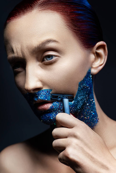 Fashion photo. Woman shaving glitter on her face  - Фото, зображення