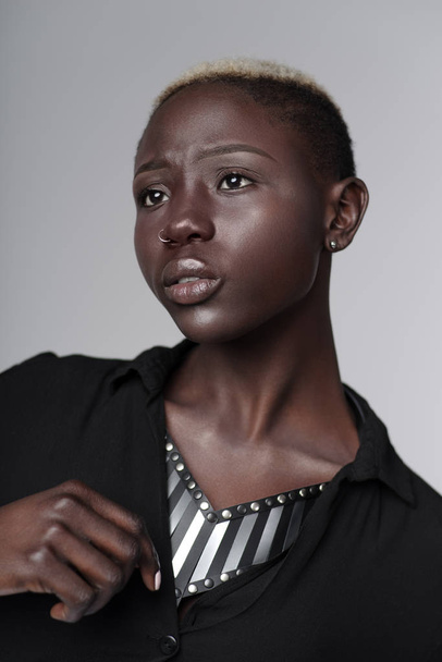 portret pięknej afrykańskiej amerykańskiej kobiety noszący skórzany naszyjnik z wkładkami metalowymi stwarzających na jasnym szarym tle  - Zdjęcie, obraz
