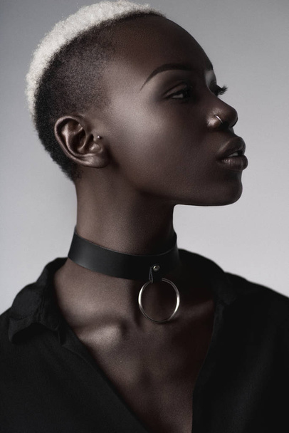 sensual african american woman wearing leather choker posing on light grey background  - 写真・画像