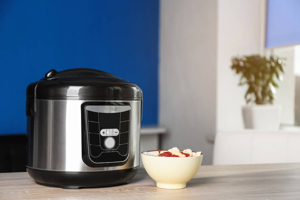Modern multi cooker and ingredients on table indoors, space for text - Foto, Imagem