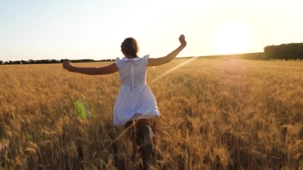 ребенок играет супергероя в поле. счастливая маленькая девочка летит в поле спелой пшеницы, на фоне заката. Замедление. Концепция счастливого детства
. - Кадры, видео