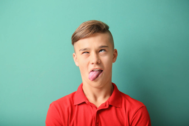 Vicces portréja tizenéves fiú színes háttérrel - Fotó, kép