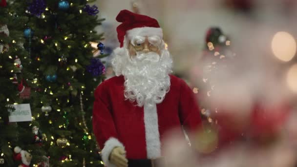View of Santa Claus doll dancing surrounded by christmas trees. - Materiał filmowy, wideo