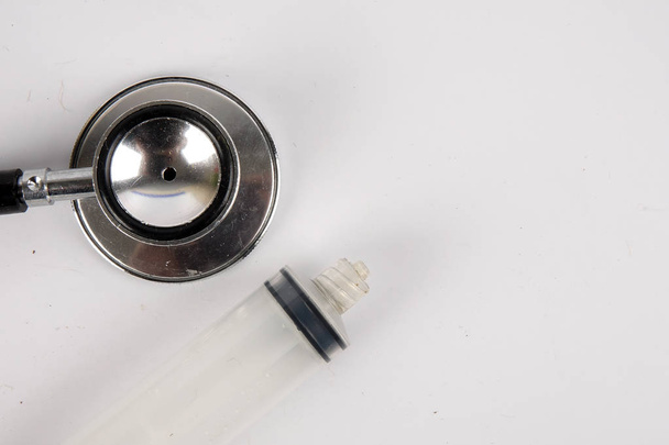 Медицинская концепция со стетоскопом, шприцем и датчиком артериального давления, изолированными на белом. Копировальное пространство
 - Фото, изображение