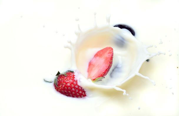 Deliciosa fresa salpicando en la leche
 - Foto, Imagen