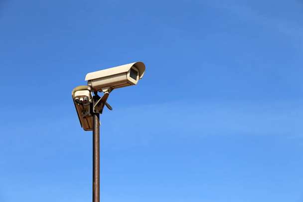 Térfigyelő kamerák egy rúdra elszigetelt tiszta kék ég. CCTV kamera, biztonsági, antiterrorism és a bűnözés elleni védelem koncepciója - Fotó, kép