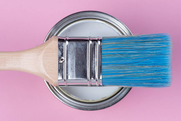 Can tin of white paint and paintbrush on pastel pink background top view - Fotografie, Obrázek