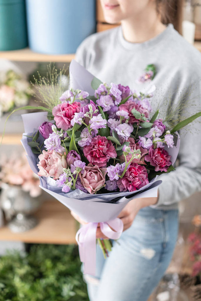 красивый свежий букет смешанных цветов в руке женщины. работа флориста в цветочном магазине. Весеннее настроение
 - Фото, изображение