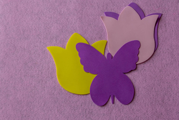 Violet butterfly and yellow flower made of soft material on rose background - Photo, Image