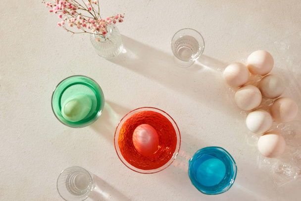 Πασχαλινά αυγά βαφή σε ποτήρι με χρώματα - Φωτογραφία, εικόνα