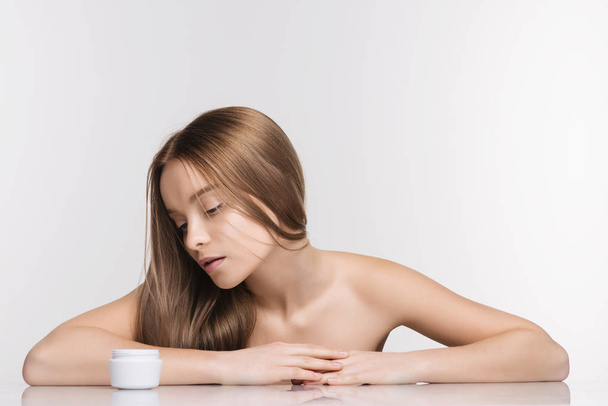 Menina spa bonita com frasco de creme isolado no fundo branco
 - Foto, Imagem