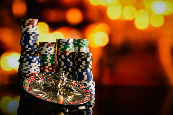  Casino-Hintergrund, Pokerchips am Spieltisch, Roulette-Rad in Bewegung - Foto, Bild