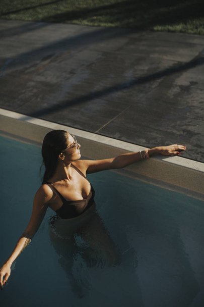 Dość młoda atrakcyjna kobieta cieszy się w odkrytym basenie w okresie letnim - Zdjęcie, obraz