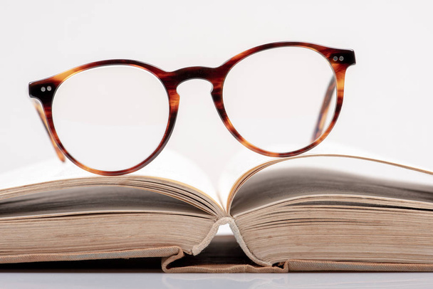 Eyeglasses on open book close-up - Fotoğraf, Görsel