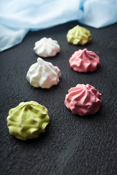 Homemade sweets - meringue on a black background, vertically. - Foto, Imagen