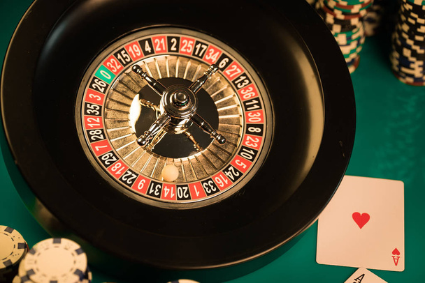  casino background, poker chips and cards on gaming table, roulette wheel in motion - Foto, imagen