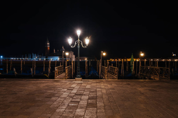 Velencei csatorna történelmi épületekkel és gondolákkal éjszaka. Olaszország. - Fotó, kép